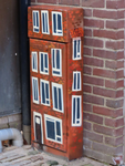 848543 Afbeelding van een als huis beschilderd schakelkastje in de Zakkendragerssteeg te Utrecht.